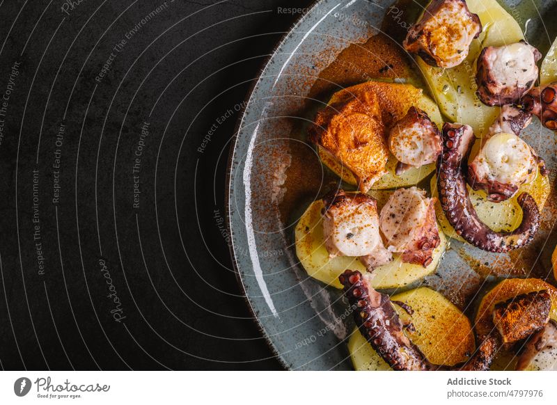 Octopus with potato on plate octopus tentacle seafood serve cuisine culinary dish meal product delicious palatable portion delectable kitchen tasty yummy
