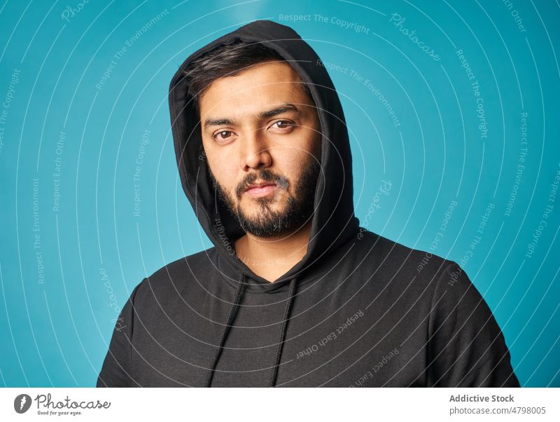 Confident man in black hoodie appearance style casual informal trendy confident fashion outfit mustache studio serious beard male light cool handsome gaze stare