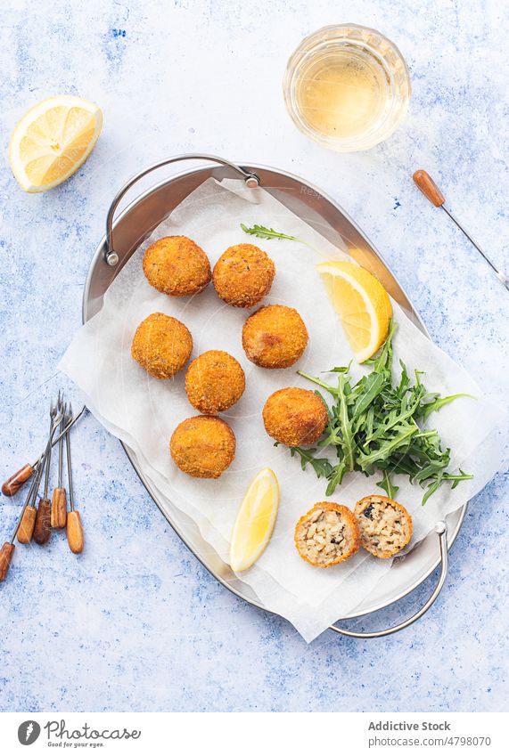 Arancini rice balls placed on metal tray on table rice arancini leftover blue background appetizer bread crumbs rice croquettes fried arancini risotto balls