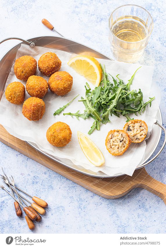 Arancini rice balls placed on metal tray on table rice arancini leftover blue background appetizer bread crumbs rice croquettes fried arancini risotto balls
