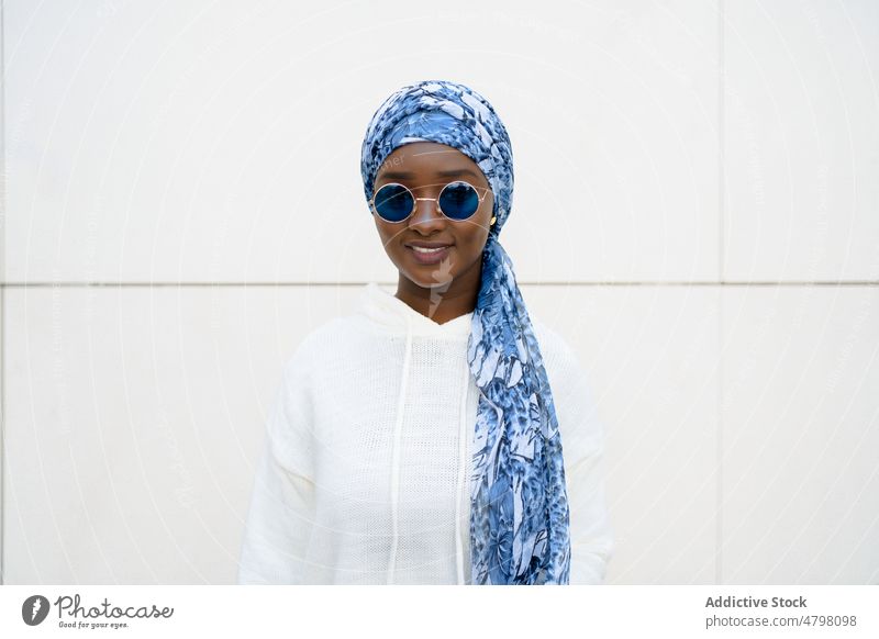 Happy stylish black woman in headscarf and sunglasses smiling at camera portrait smile self assured style cool fashion happy content charismatic trendy