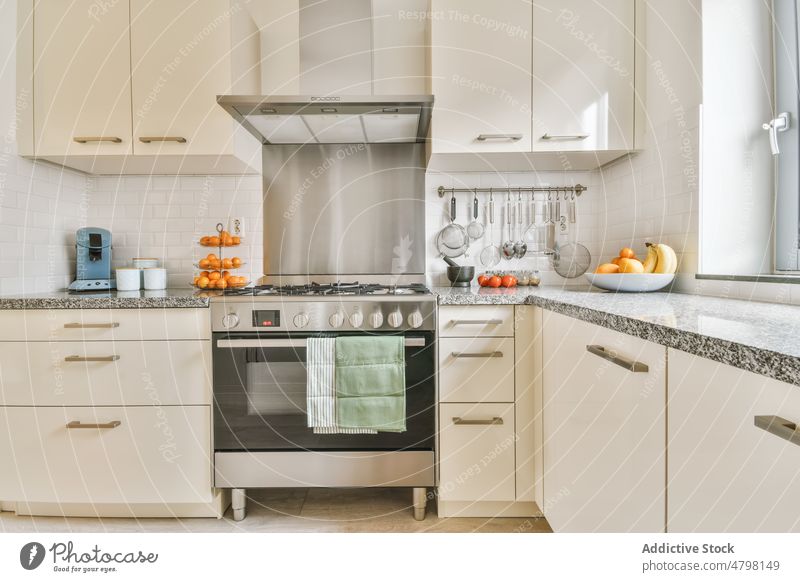 Interior of kitchen with appliances interior apartment design style counter kitchenware modern mandarins cabinet residential window home convenient hood utensil