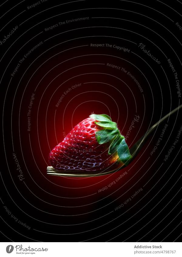 Ripe red strawberry with green leaf on fork sweet organic natural flavor style product tasty fresh cutlery utensil dim delicious studio ingredient food