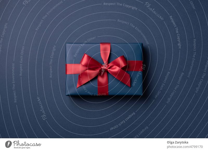 Blue gift box on blue background. red christmas minimal one top view luxury premium birthday present card new year holiday elegant fathers greeting