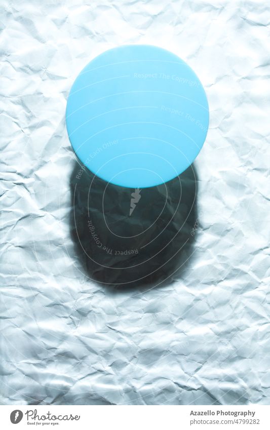 Round blue object on abstract blue background. Minimalist flat lay single object with shadow. still life minimalism water wet blur blurry texture circle sphere