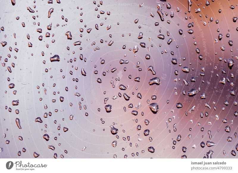 raindrops on the window in rainy days water wet glass transparent surface closeup abstract background textured bright splash droplet condensation liquid