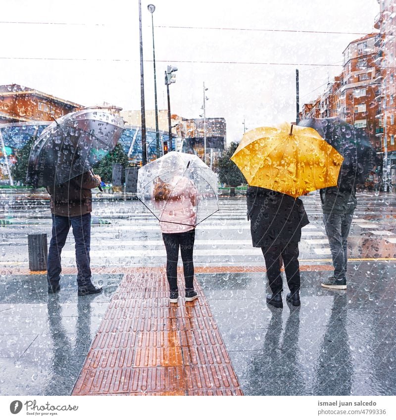 people with an umbrella in rainy days person raining water human pedestrian street city urban bilbao spain walking lifestyle weather winter spring springtime