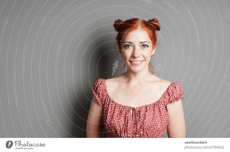 happy young woman with big toothy smile and red hair space buns - a Royalty  Free Stock Photo from Photocase