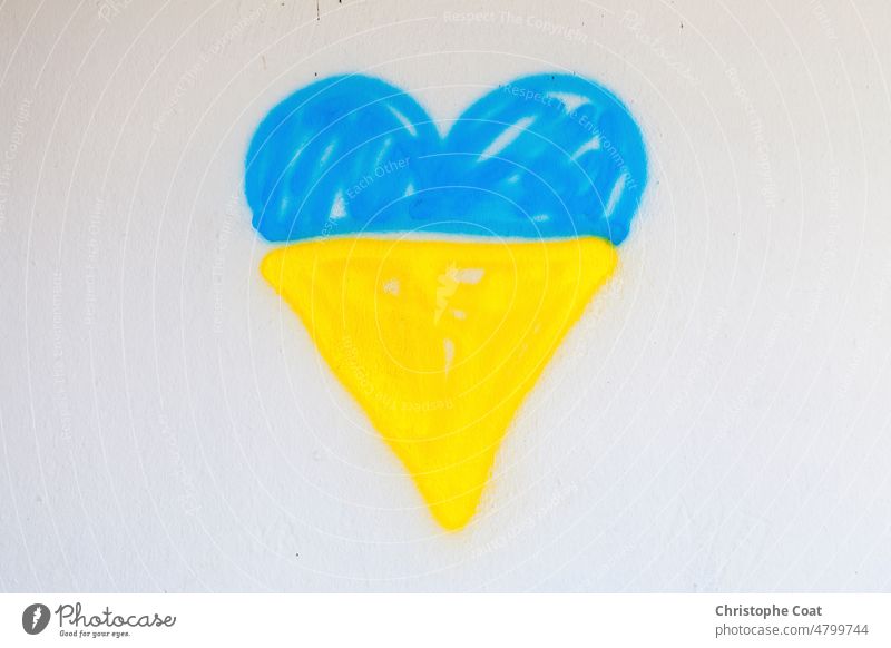 Spray painted Ukrainian flag shaped into a heart no people street art graffitti wall horizontal Photography war hope love