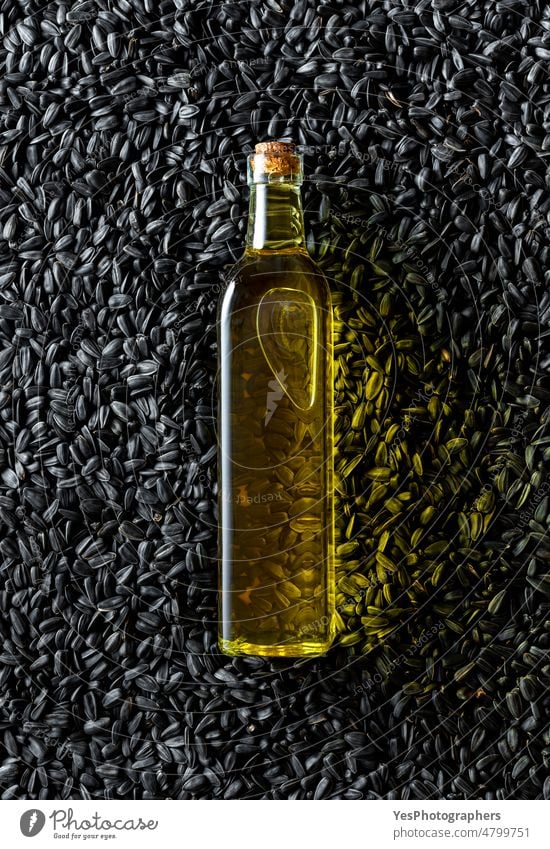 Oil bottle on a pile of black sunflower seeds, above view. agriculture backdrop background cereal close-up color cooking copy space design fat flat lay food