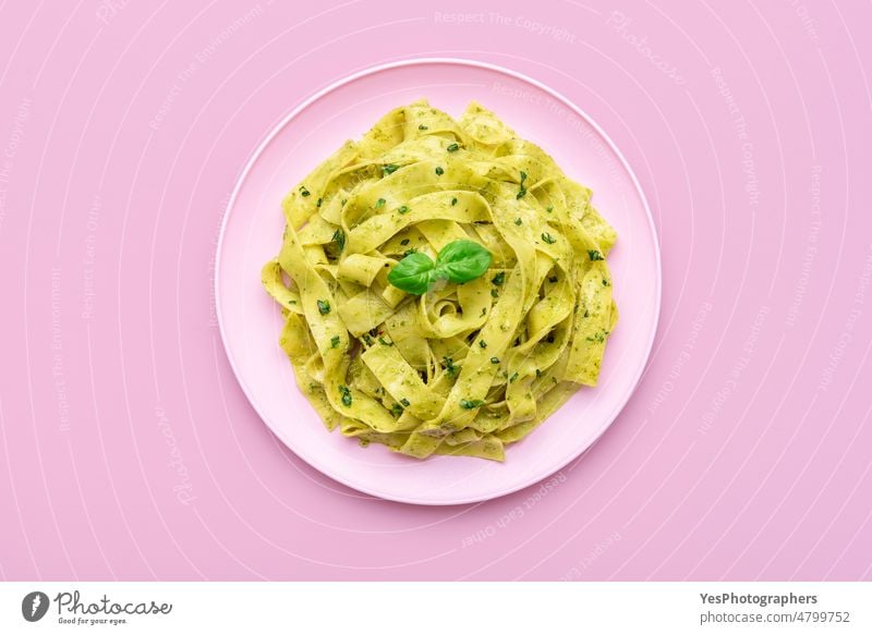 Pasta with pesto sauce minimalist on a pink background above alfredo basil bright carbs color cooked cuisine delicious dinner dish fettuccine flat lay food