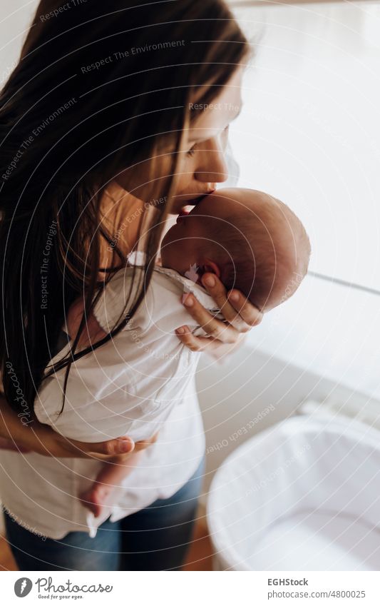 Close up young mother kissing newborn baby on forehead close up mom mum woman female newbbaby child person family care childhood love holding lifestyle daughter