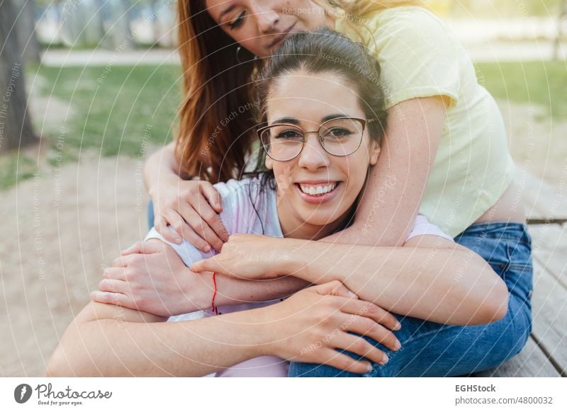 Close up two happy girlfriends embracing looking at camera smiling close up two person smile glasses together hug affectionate hugging togetherness joy embrace