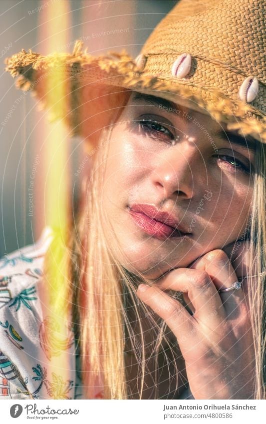 Portrait with light effect of a young beautiful blonde with green eyes wearing straw hat portrait close-up pretty lifestyle people attractive young woman girl