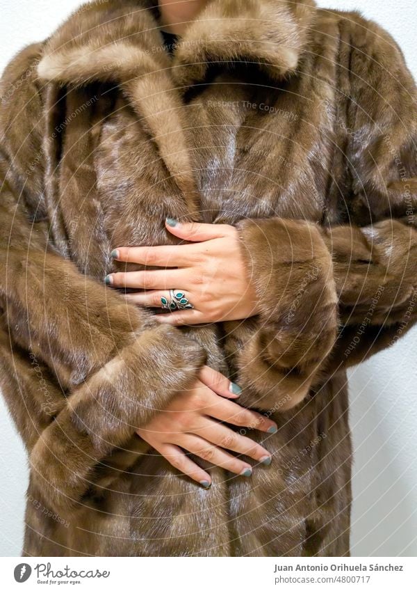 Unrecognizable stylish woman in rich fur coat. Woman's hand with blue painted nails lifestyle people luxurious expensive brown wear woman's hand fashion