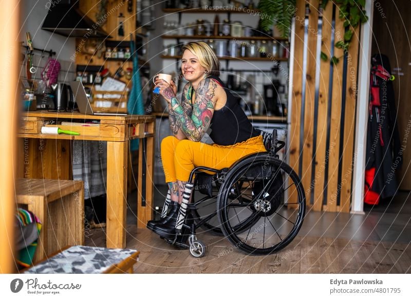 Portrait of an young tattooed woman in a wheelchair at home domestic life confidence indoors house people adult casual female Caucasian attractive beautiful
