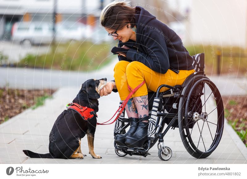 Woman in wheelchair with her dog outdoors domestic life confidence woman indoors home house people young adult casual female Caucasian attractive beautiful