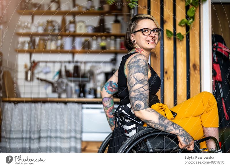 Portrait of young tattooed woman in wheelchair at home Wheelchair Living or residing Self-confidence Woman indoors Home House (Residential Structure) people