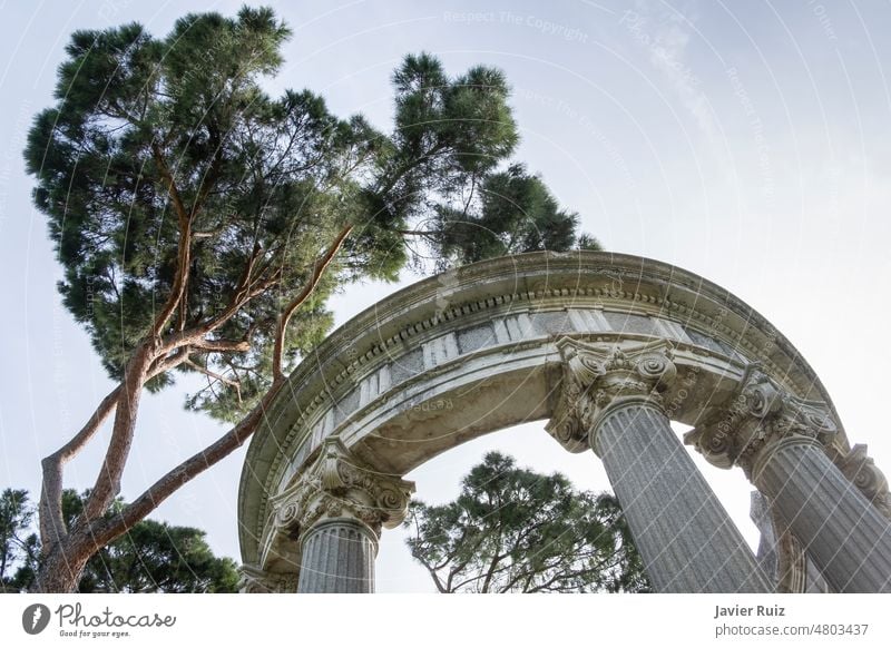 templete, pavilion or colonnade with tall trees in the background, columns with decorated capitals, El Capricho park, Alameda de Osuna Madrid capitel