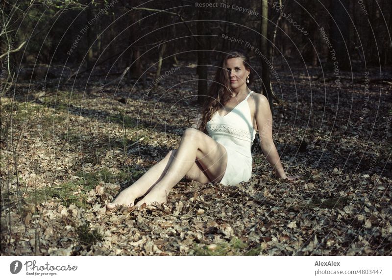 analog 35mm portrait of young woman in white dress sitting in forest Woman Young woman pretty Feminine feminine Identity Authentic Esthetic Adults naturally