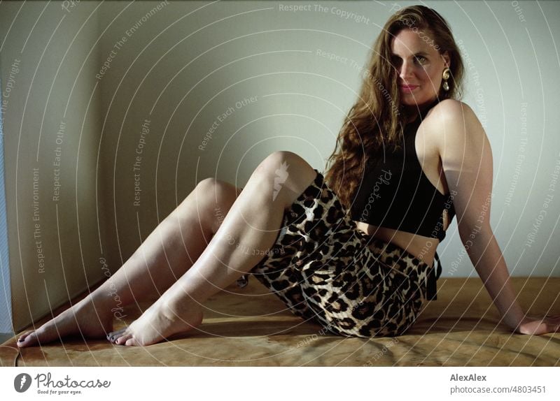 Young woman sitting on leather sports mat and wearing leopard print pants Woman pretty Feminine feminine Slim leop print Identity Analog analog image