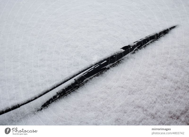 car windshield wiper and a snow-covered windshield auto automobile background black closeup cold defrost defrosting detail frozen glass ice icing nature outdoor