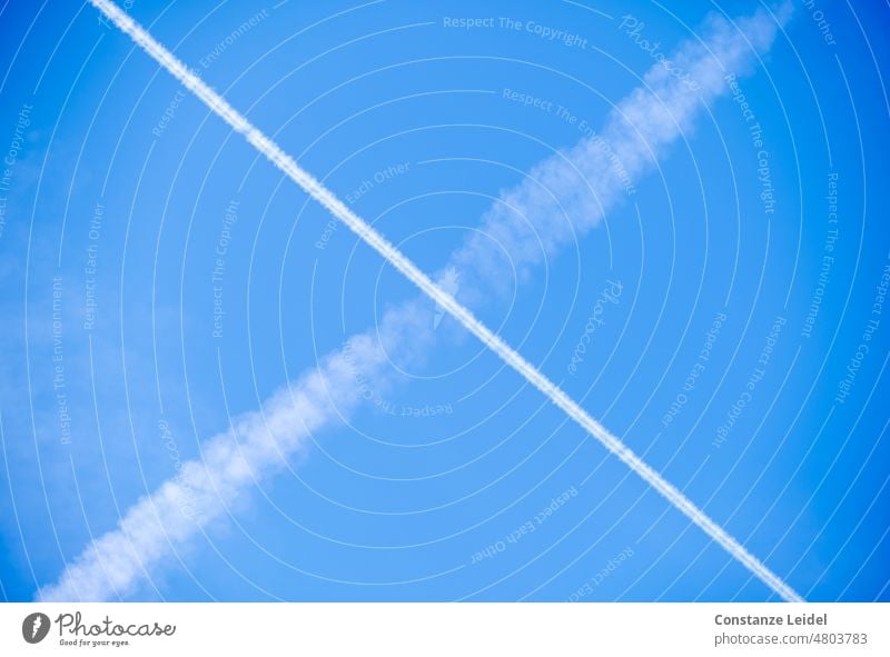 Contrails of airplanes crossing in the blue sky. Vapor trail Sky Aviation Airplane Clouds Blue Vacation & Travel Beautiful weather Flying Exterior shot Tourism