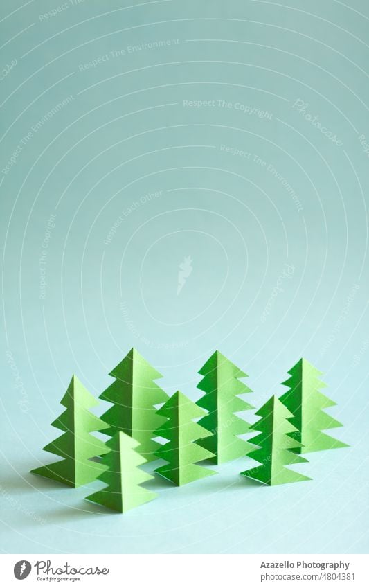 Paper forest with free copy paste space for text. Green paper trees on blue background. abstract concept conceptual creative design ecological ecology