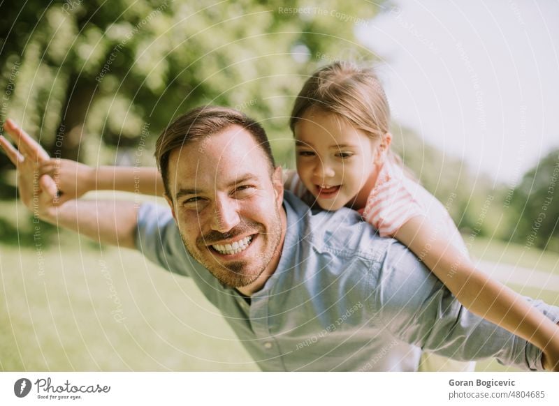 Father with daughter having fun at the park beautiful beauty caucasian child childhood closeness dad day enjoying expressions exterior family father fatherhood