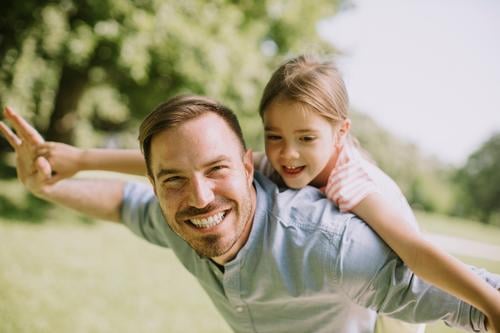Father with daughter having fun at the park beautiful beauty caucasian child childhood closeness dad day enjoying expressions exterior family father fatherhood