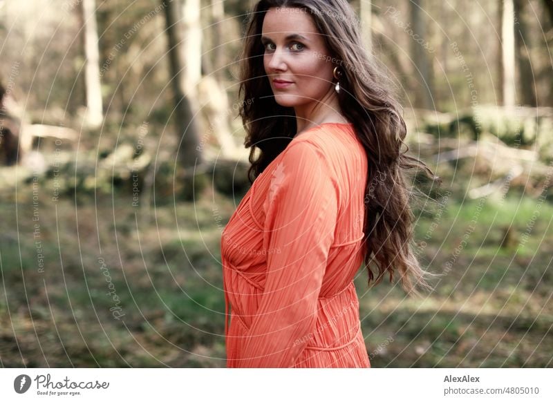 side portrait of young woman in orange dress standing in forest Woman Young woman pretty Feminine feminine Identity Authentic Esthetic Adults naturally