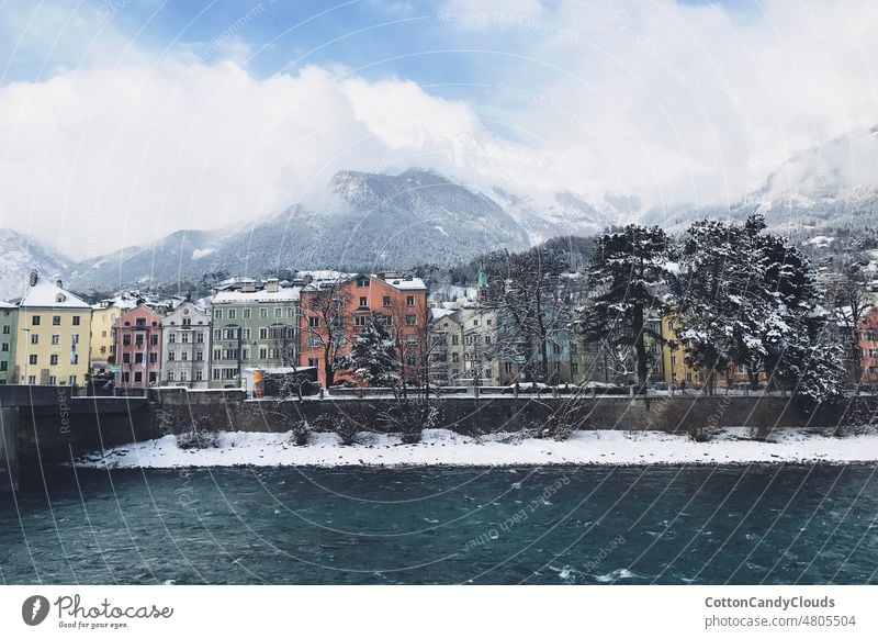 Coloured houses in Innsbruck next to the river coloured houses colours innsbruck austria winter snow mountain clouds travel ski holiday boat sea ship water sky
