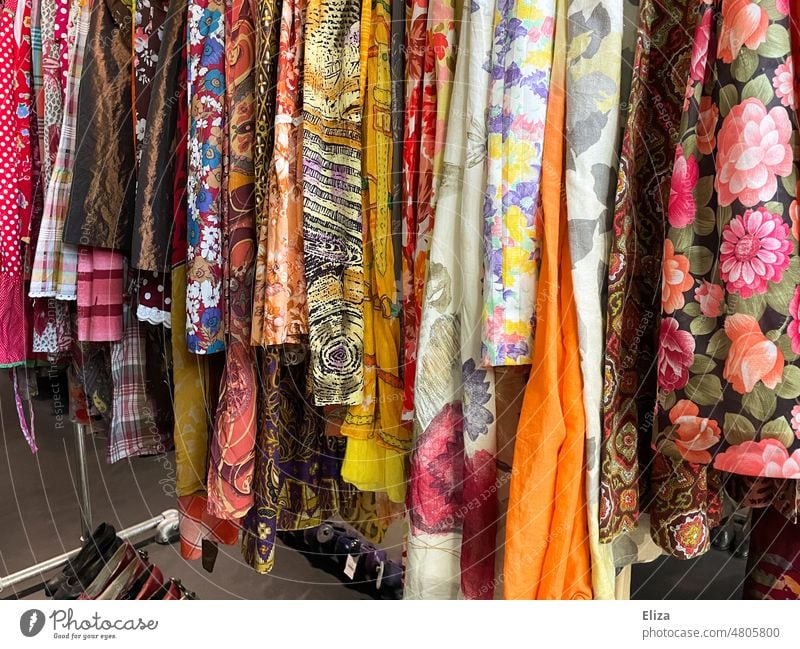 Colorful and wildly patterned clothes in a second hand store variegated eyeballed Retro vintage garments Second-hand Flea market Second-hand shop Substances