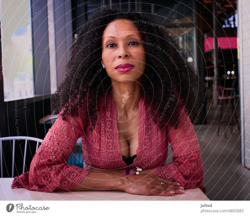 Portrait of curly-haired black woman at a bar table Elderly Adult Aged Beauty Fashion Lady Mature Middle Natural Trendy Street Pretty Woman Portrait city Skin