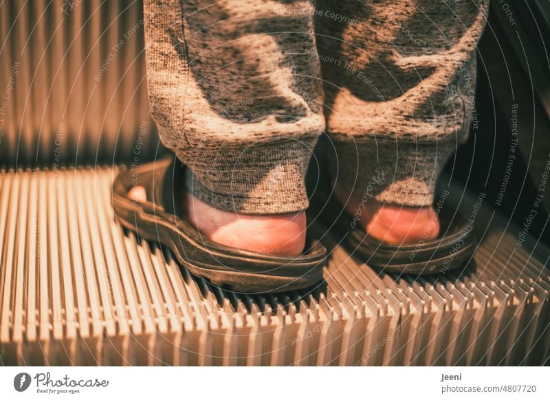 [hansa BER 2022] On the road in bathing slippers Man Human being Beach shoes Barefoot feet Sweatpants Feet Escalator unusual Skin Town In transit Stand Wait
