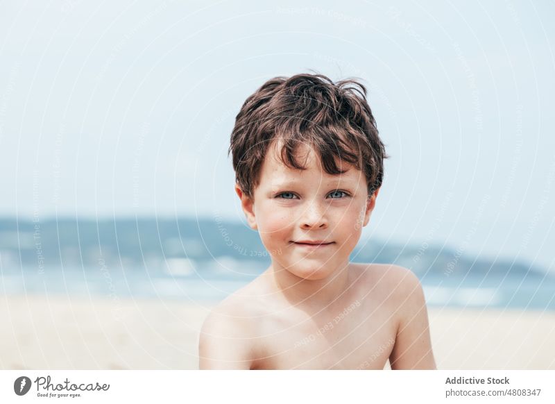Boy looking at camera on beach - a Royalty Free Stock Photo from Photocase
