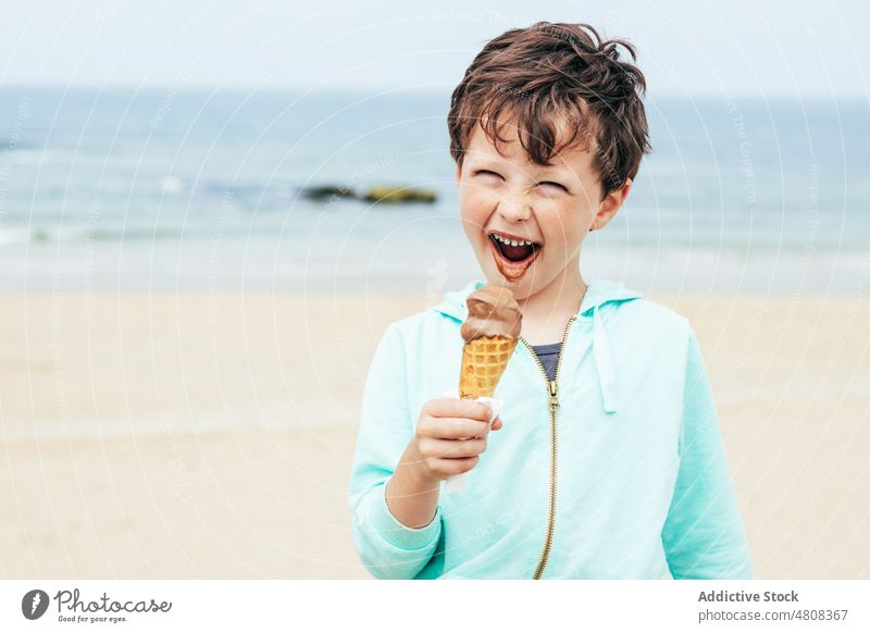 Smiling boy eating chocolate ice cream lick smile summer weekend beach portrait sweet kid seaside child dessert cute delicious vacation yummy adorable childhood