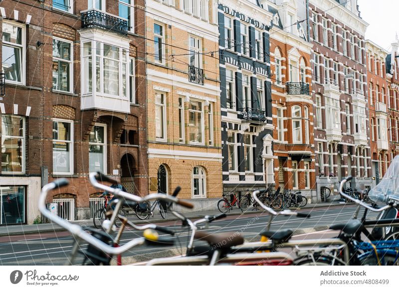 City street with aged brick buildings and bikes parked at roadside city facade residential architecture bicycle exterior district typical neighborhood window