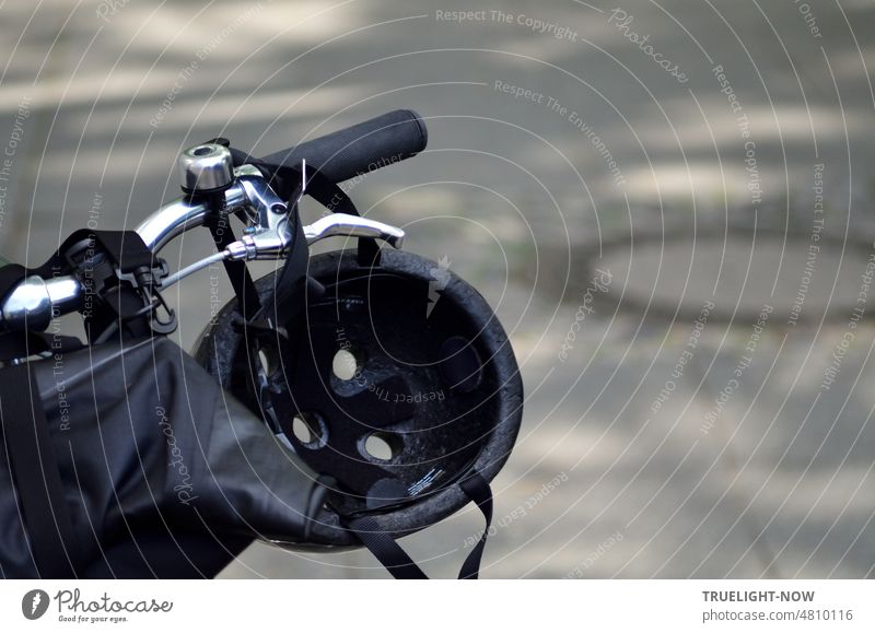 [hansa BER 2022] Detail of a hipster bicycle handlebar with brake lever, bell, handlebar grip, crash helmet in front of gray asphalt Bicycle Design