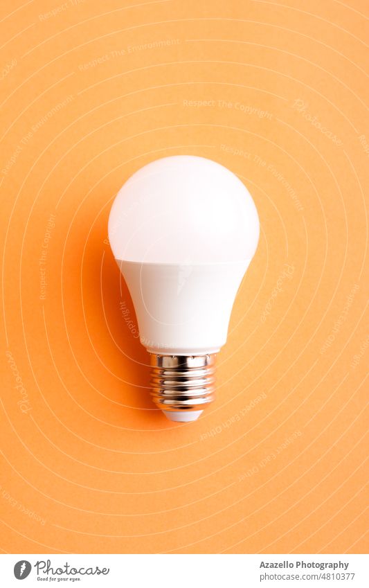 White economy light bulb on orange background. bright business color concept copy creative daylight device electric electricity energy free glass glow glowing
