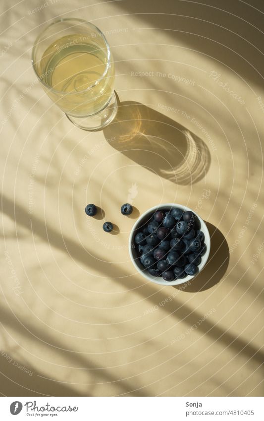 A glass of wine and fresh blueberries on a beige table. Drop shadow. Vine White Blueberry Sunlight Silhouette Shadow Shadow play Structures and shapes Light