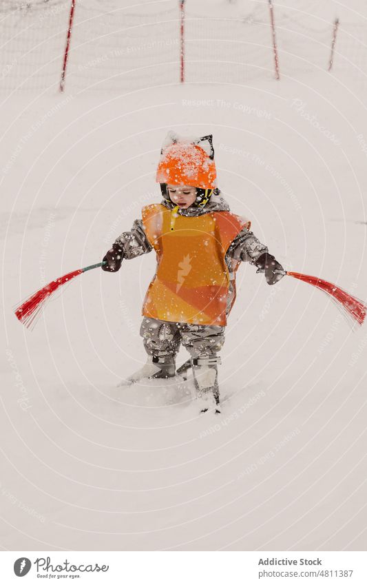 Attentive little kid with brushes balancing on skis on snowy terrain child practice winter ski resort attentive balance sport activity nature toddler hobby