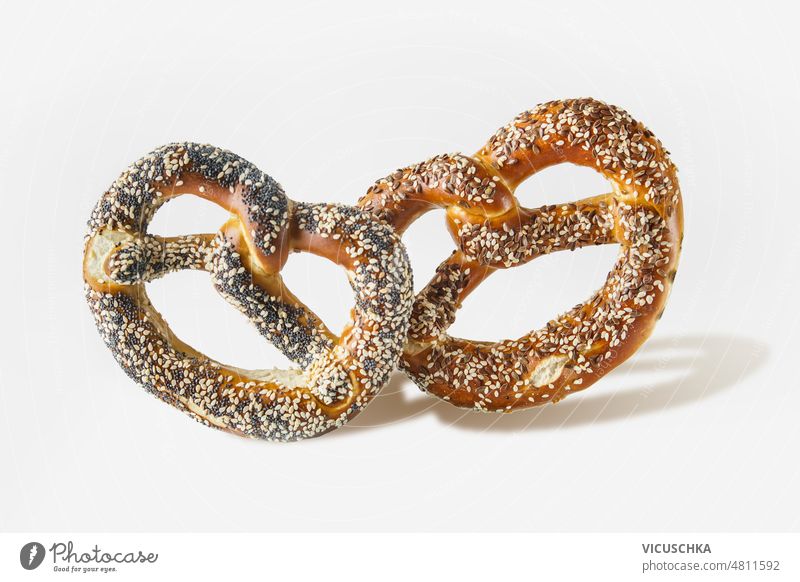 Two Bavarian pretzels with sesame and poppy seeds at white background. bavarian german buns two delicious front view baked item bakery bread food german food