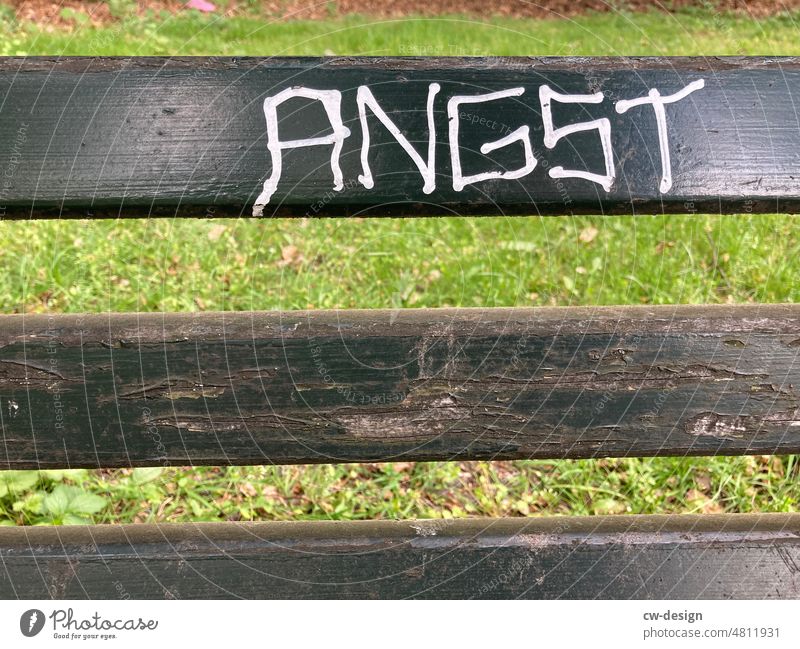 ANGST- smeared with white sharpie on brown park bench Roller shutter Wood Line Structures and shapes Deserted Architecture Colour photo Town Pattern Light