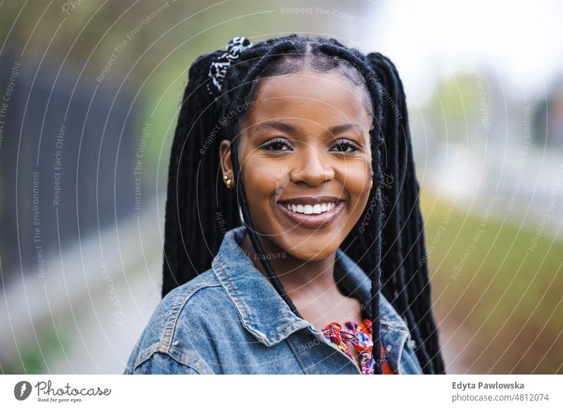 Portrait of a beautiful young woman in the city cool carefree confident day millennials dreadlocks enjoy authentic positive real people joyful toothy smile