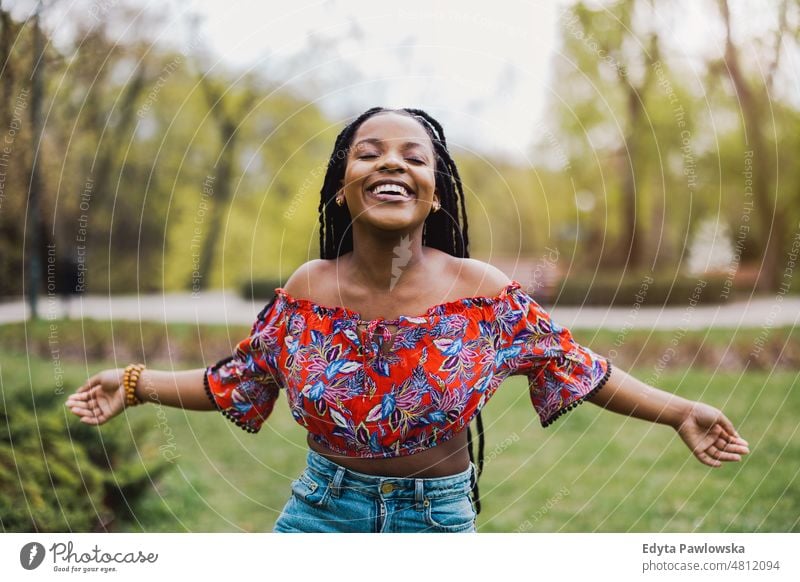 Beautiful young woman enjoying spring in the park cool carefree confident day millennials dreadlocks authentic positive real people joyful toothy smile