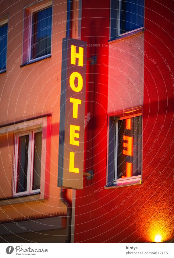 Hotel. Illuminated sign for a hotel in the city at night Neon sign Characters neon sign Hotel industry hotel industry Light Billboard Spotlight house facade