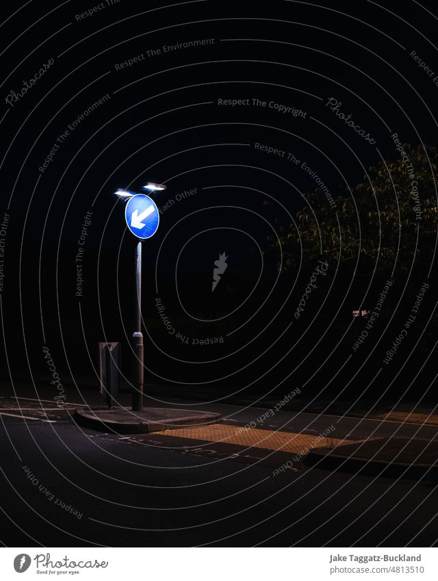 Vertical shot of a British 'Keep Left' road sign at night with contrasted heavy artificial lighting british transport travel left soap abstract sphere water
