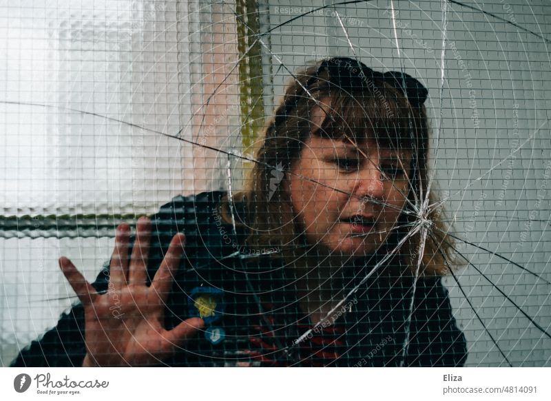 [hansa BER 2022] Woman inspects cracked window pane Broken jumped Window pane Glass shattered Pane Vandalism Smashed window Damage Crack & Rip & Tear Transience