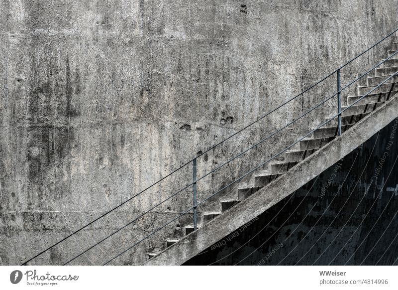 A staircase leads up a rounded concrete wall that was damaged long ago. Stairs stagger Facade Wall (building) Round Curve damages Bullet holes War rail Tall